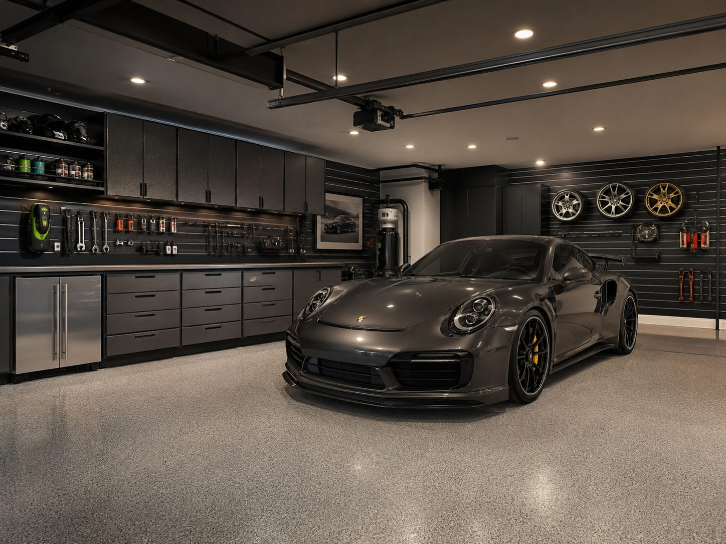 Luxury garage with epoxy flake floor, dark cabinetry, slatwall storage, and Porsche 911